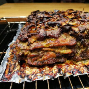 Der fertig gegarte Gyros-Schichtbraten im Ofen mit knuspriger Kruste, auf einem Rost gebacken.