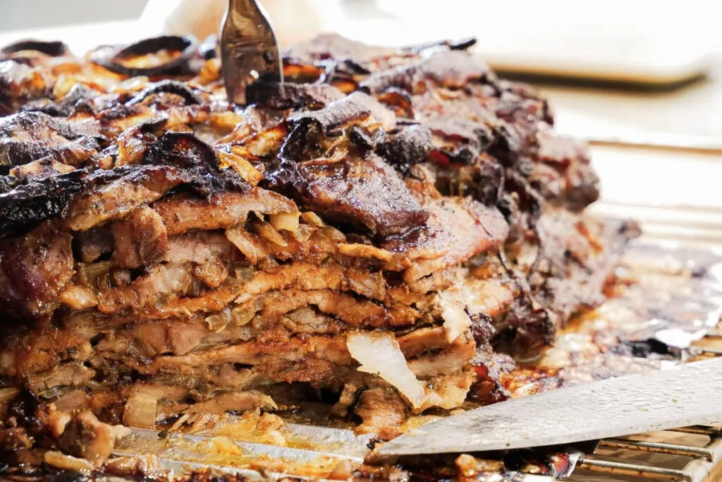 Ein saftiger Gyros-Schichtbraten aus mehreren Schichten mariniertem Fleisch, das goldbraun und knusprig gebraten wurde.